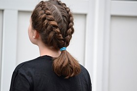 发型女孩女生两个小穗被加入一个马尾辫，背景为白色的门