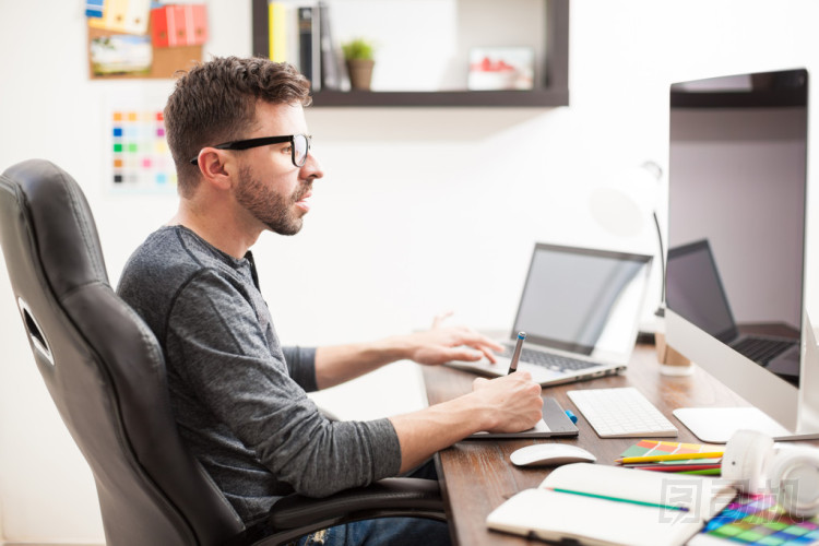 使用兩臺計算機(jī)的人圖片