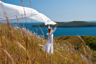 白色禮服與織物的手在風(fēng)中的女孩