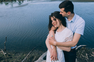 熱戀中擁抱湖附近的情侶照片