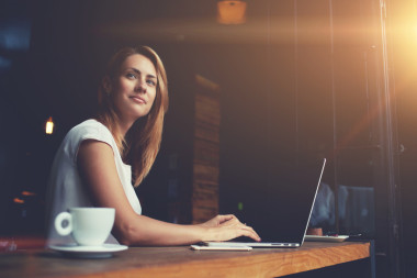 在筆記本電腦上工作期間新思考的年輕迷人女性自由職業(yè)者