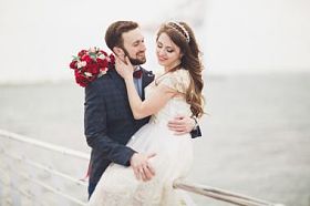 刚结婚的婚礼夫妇海滩上散步，在日落时分