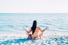 女人在做瑜伽在海滩图片