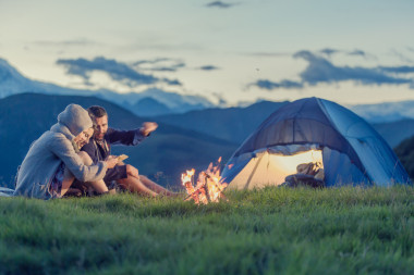 三個(gè)朋友在日落時(shí)分與火山上露營(yíng)