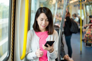 使用手機(jī)內(nèi)火車的女人照片
