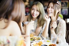 快乐的女性朋友坐着聊天，在餐厅