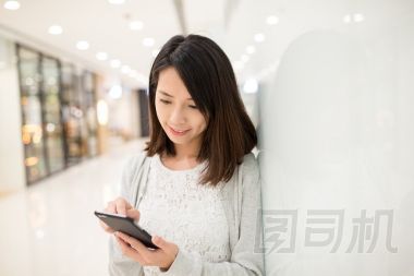 女人在購(gòu)物商場(chǎng)中使用手機(jī)