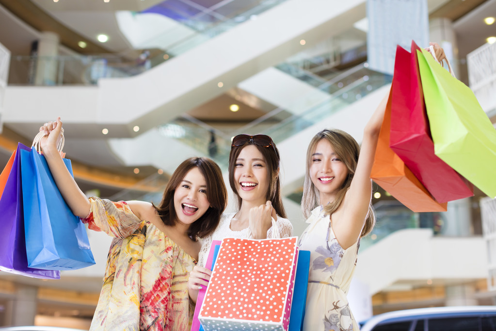 快乐妇女组携带购物袋在购物中心 快乐妇女组携带购物袋在购物中心
