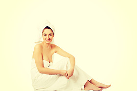 年轻人微笑坐着的女人裹着毛巾