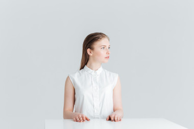 女人坐在桌前，看著別處照片