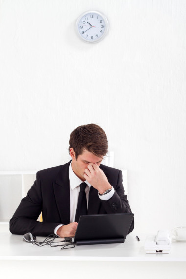 累了年輕的商人按摩他的眼睛