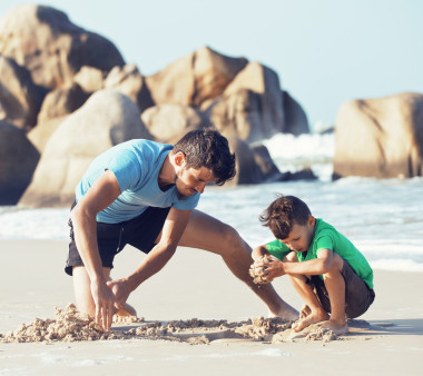 幸福的家庭，在海灘玩，父親帶兒子散步海洋海岸上