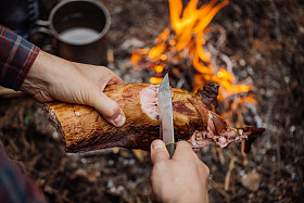 森林营地里的人在烤兔肉前视图