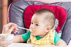 母亲给她的孩子喂婴儿食