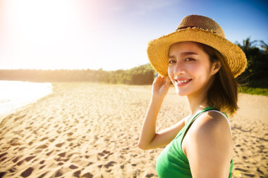 日落時(shí)在海灘上散步的美麗的年輕女子