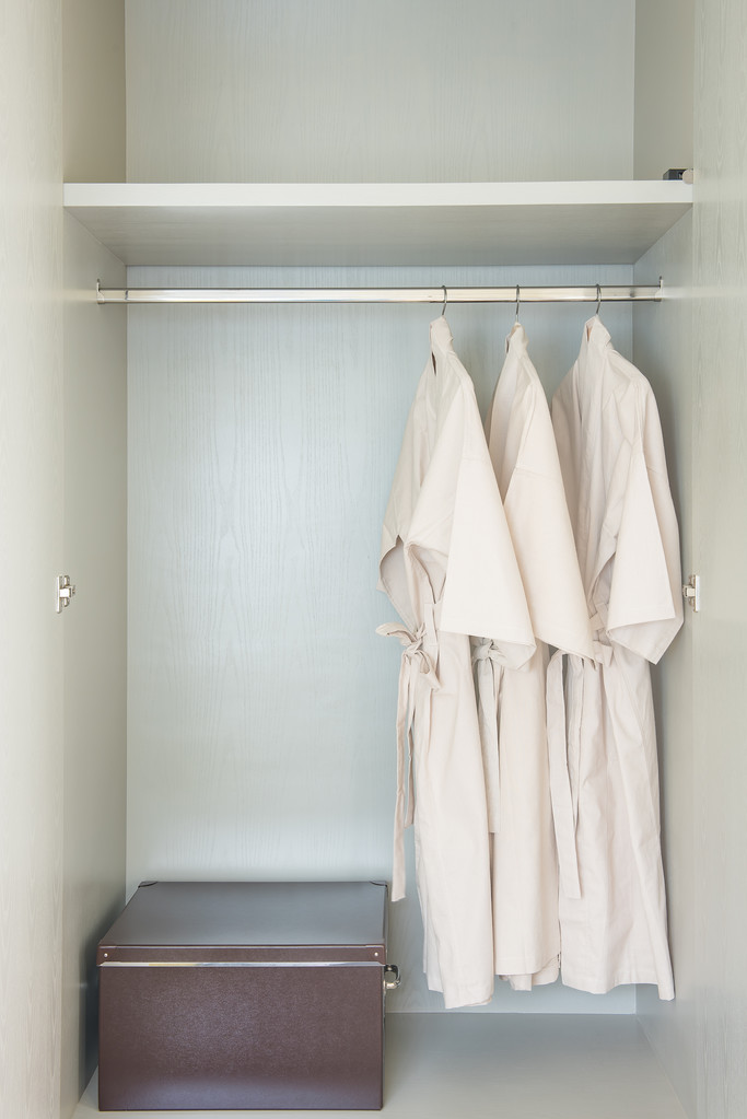 铁路在白色的木制衣柜上挂着的浴袍