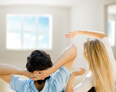 安逸的年轻夫妇在新公寓里面拥抱和规划到