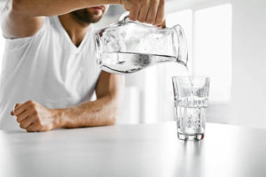 喝水。特寫人把水倒進(jìn)玻璃里。水化