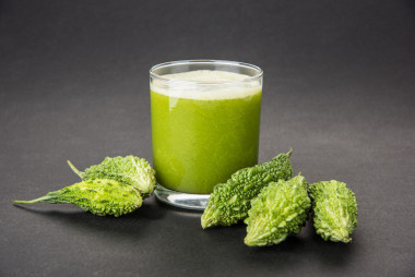 在蔬菜切片，karela 果汁或苦瓜汁一杯绿色 momodica 的草药