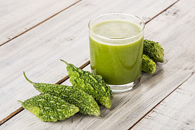 在蔬菜切片，karela 果汁或苦瓜汁一杯绿色 momodica 的草药
