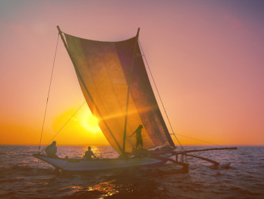 日落时双体船上的渔民