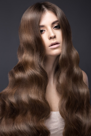 美麗的黑發(fā)女孩完美卷曲的頭發(fā)和經(jīng)典化妝。美麗的臉