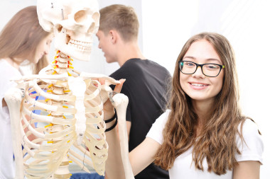 女学生观看人体骨架模型.图片