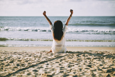 女人在早上坐在沙灘上圖片