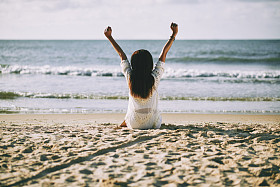 女人在早上坐在沙滩上图片