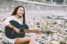 与在海滩吉他唱歌的女孩图片