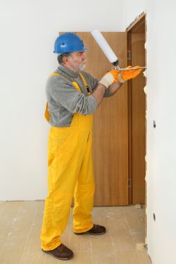 工人安裝木門，使用聚氨酯泡沫