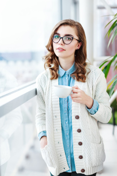 可愛的小女孩站在那兒，杯咖啡