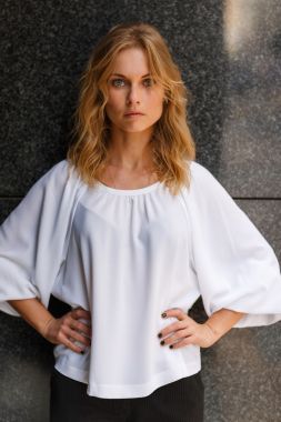 金發(fā)女人，雙手叉腰的一半增長的肖像