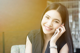 美丽的亚洲女人谈在办公室电话