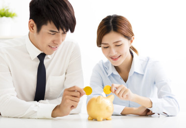 商務(wù)男人和女人將硬幣放入存錢罐