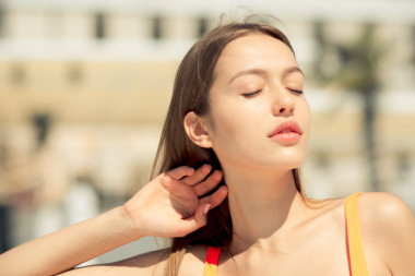 美麗的女人擁有日光浴和放松水池附近