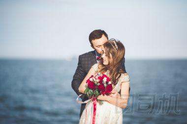 剛結(jié)婚的婚禮夫婦海灘上散步，在日落時分