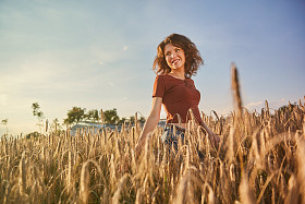 快乐的女人在金黄小麦图片