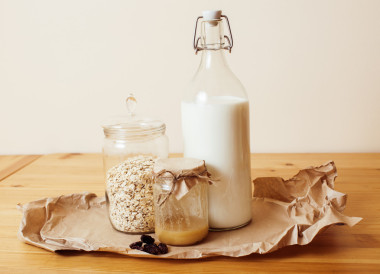 真正的安慰木制厨房早餐食材靠拢在玻璃、 蜂蜜、 燕麦粥、 牛奶、 牛奶什锦早餐