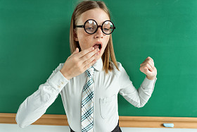 昏昏欲睡的精疲力竭或无聊的年轻学生打哈欠