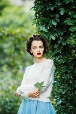 年轻的复古风格女人摆在葡萄园