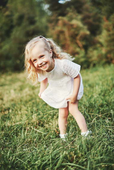 在以日落草甸上运行的小女孩图片