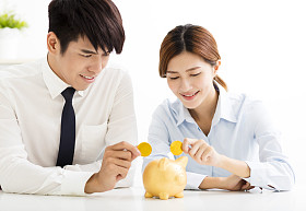 商务男人和女人将硬币放入存钱罐