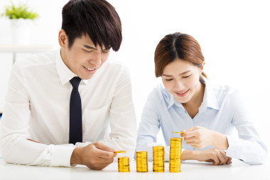 商人和女人放到堆栈的硬币照片