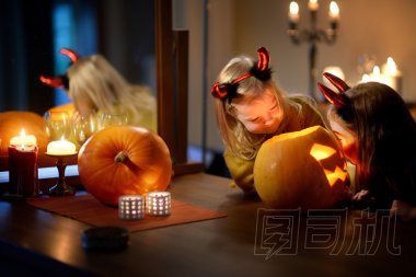 漂亮的姐妹在萬圣節(jié)雕刻南瓜照片