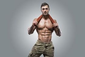 在灰色的背景上肌肉运动员健美男人