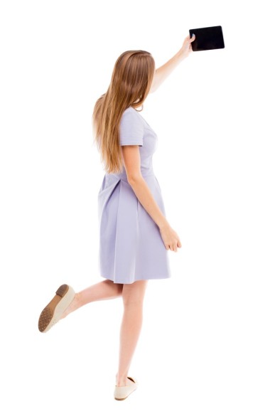 回观站年轻美丽的女人，穿着背心与使用