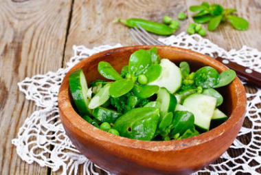 沙拉配黃瓜，馬齒莧和黑暗的磁盤上的綠豌豆