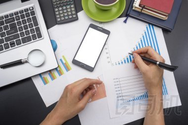 年輕女子支票帳戶的特寫。辦公室桌子與用品頂視圖