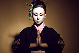 年轻的 heisha 在欢迎双手合十传统和服的肖像